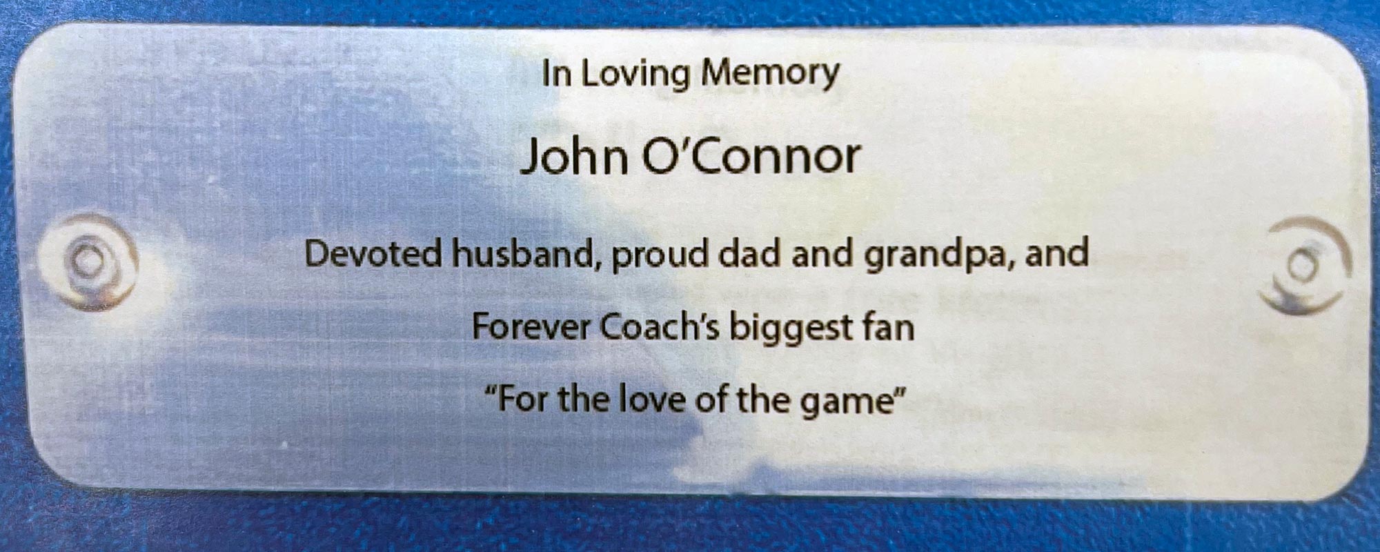 Plaque inscribed with: In Loving Memory John O'Connor Devoted husband, proud dad and grandpa, and Forver Coach's biggest gan "For the love of the game"