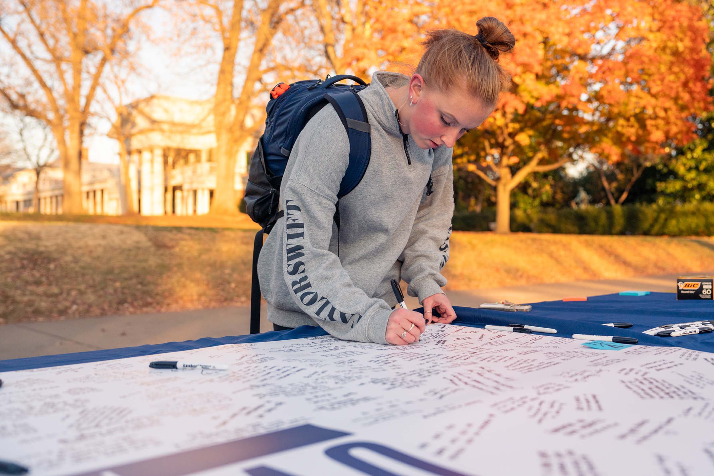 Student signing the UVA Strong banners on the Lawn