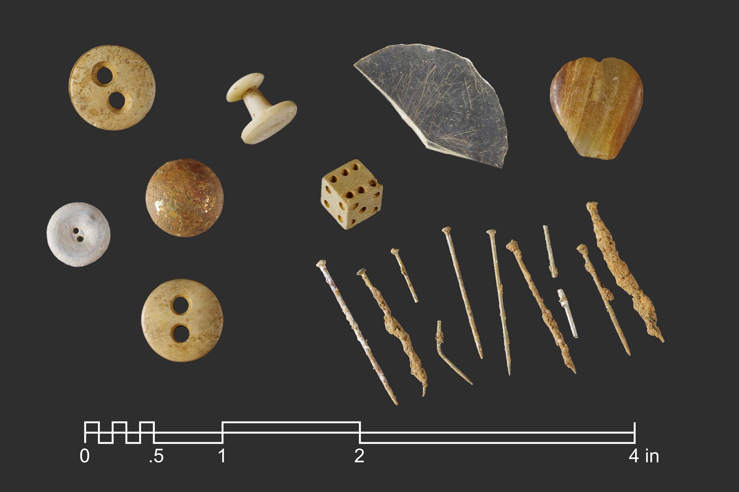 An array of small artifacts including a die, buttons, nails and various other items