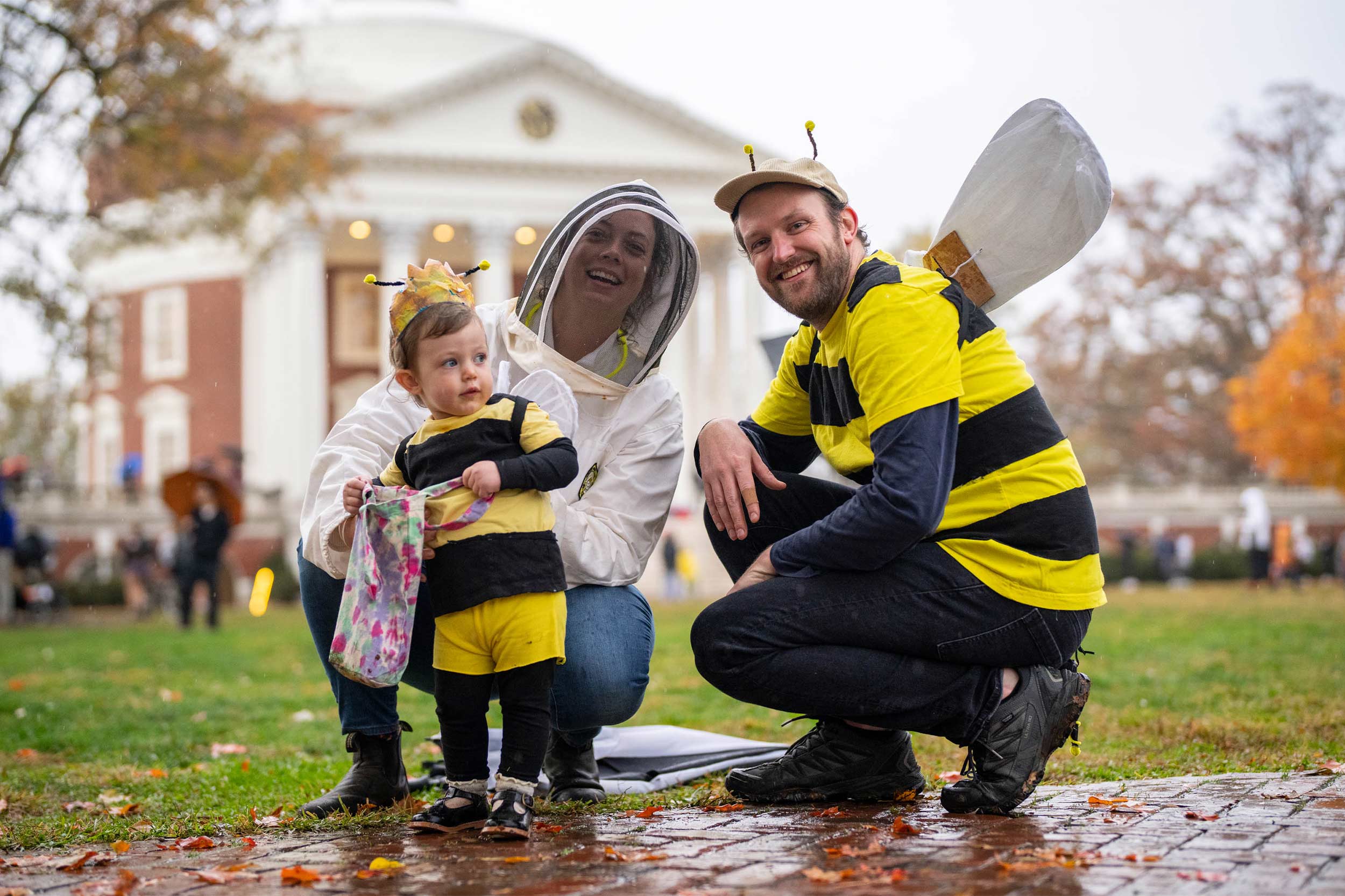 Mom dressed as a bee keeper and a man and a small dressed as bees