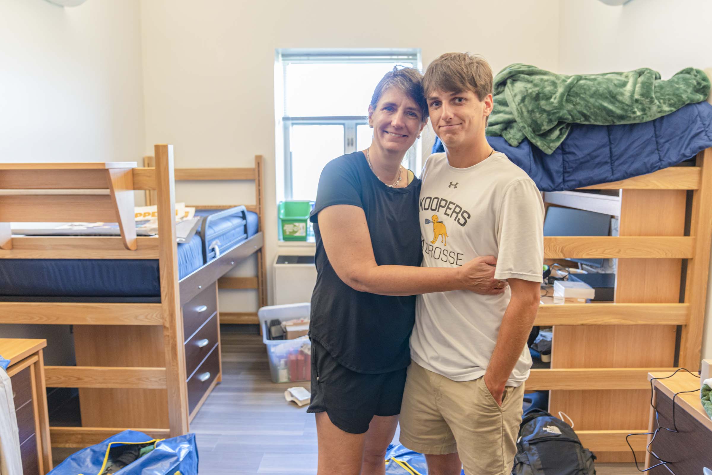 Lee posing with her son in his new dorm room
