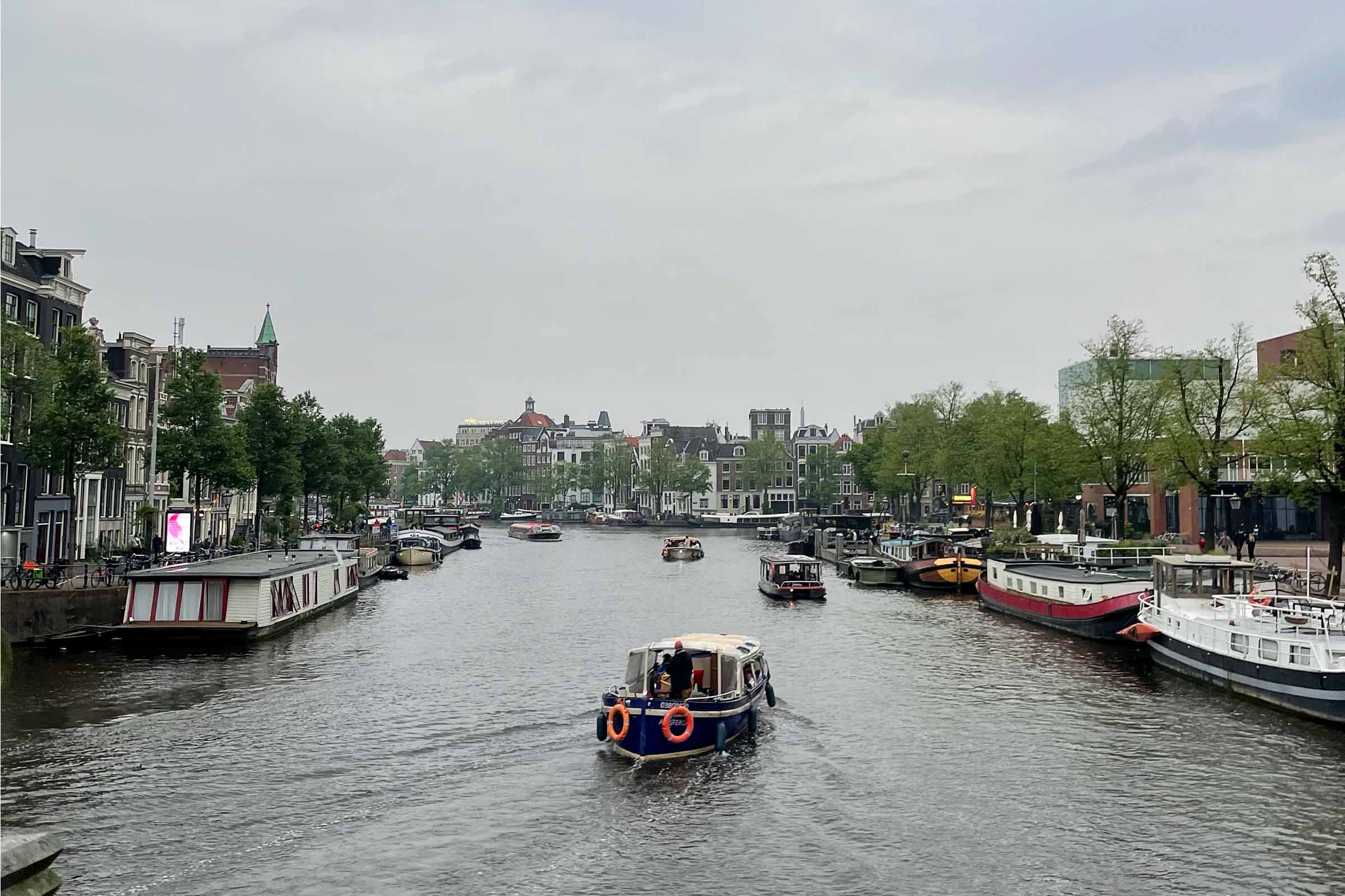 A cloudy day over the river in Amsterdam as a boat makes its way 