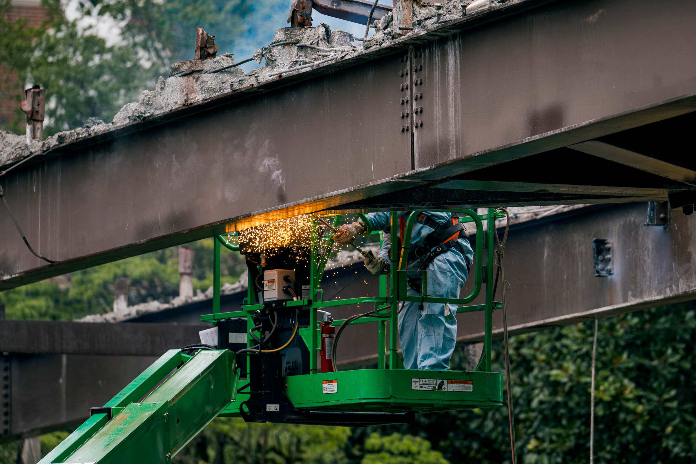 workers using torches to dismantle the steel structure of the bridge.