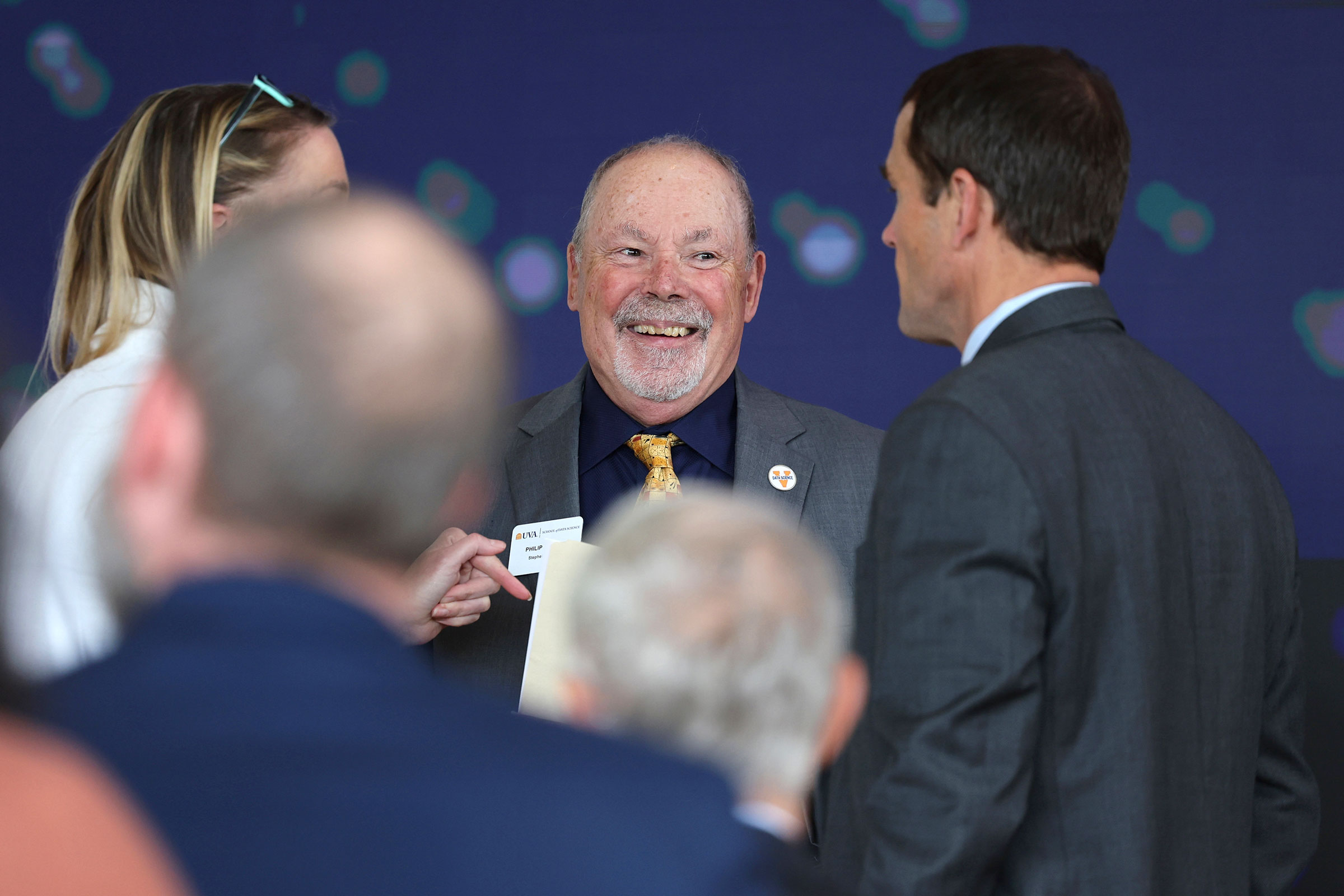 Bourne, center, chats with UVA President Jim Ryan, right, during the grand opening celebration.