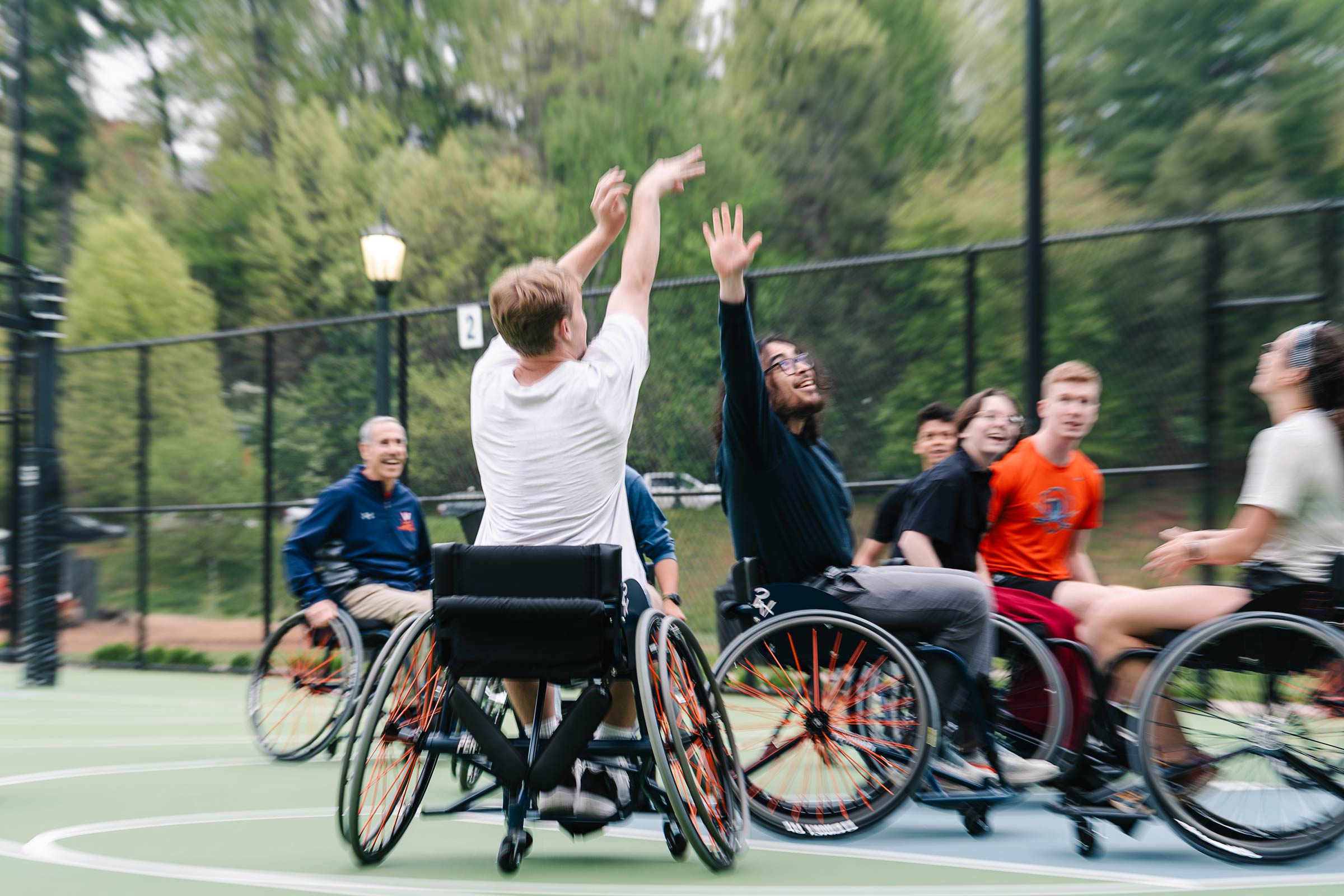 Picture of an individual with disabilities shooting basketball to score a point.