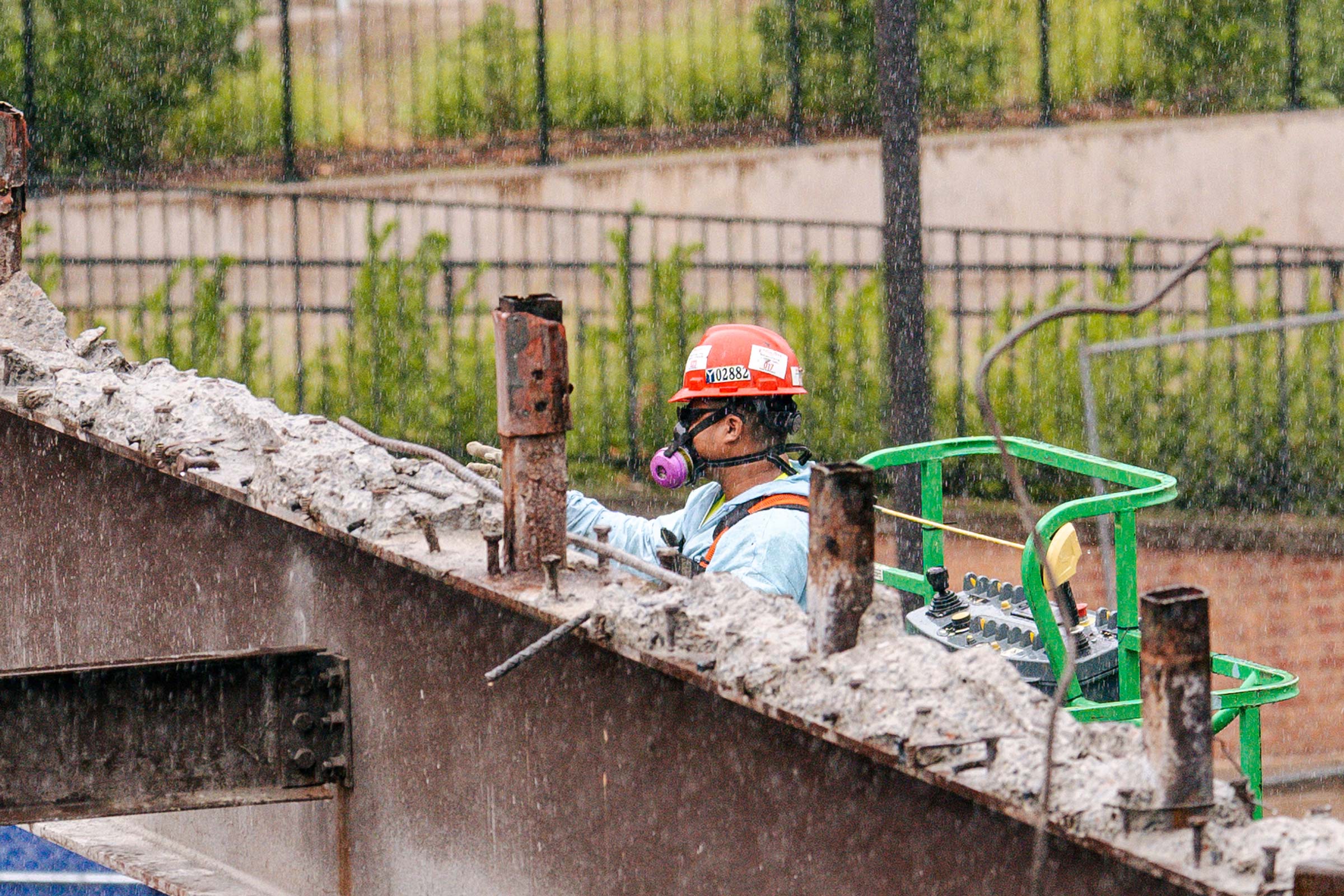 Workers using protective gear to take down the bridge.