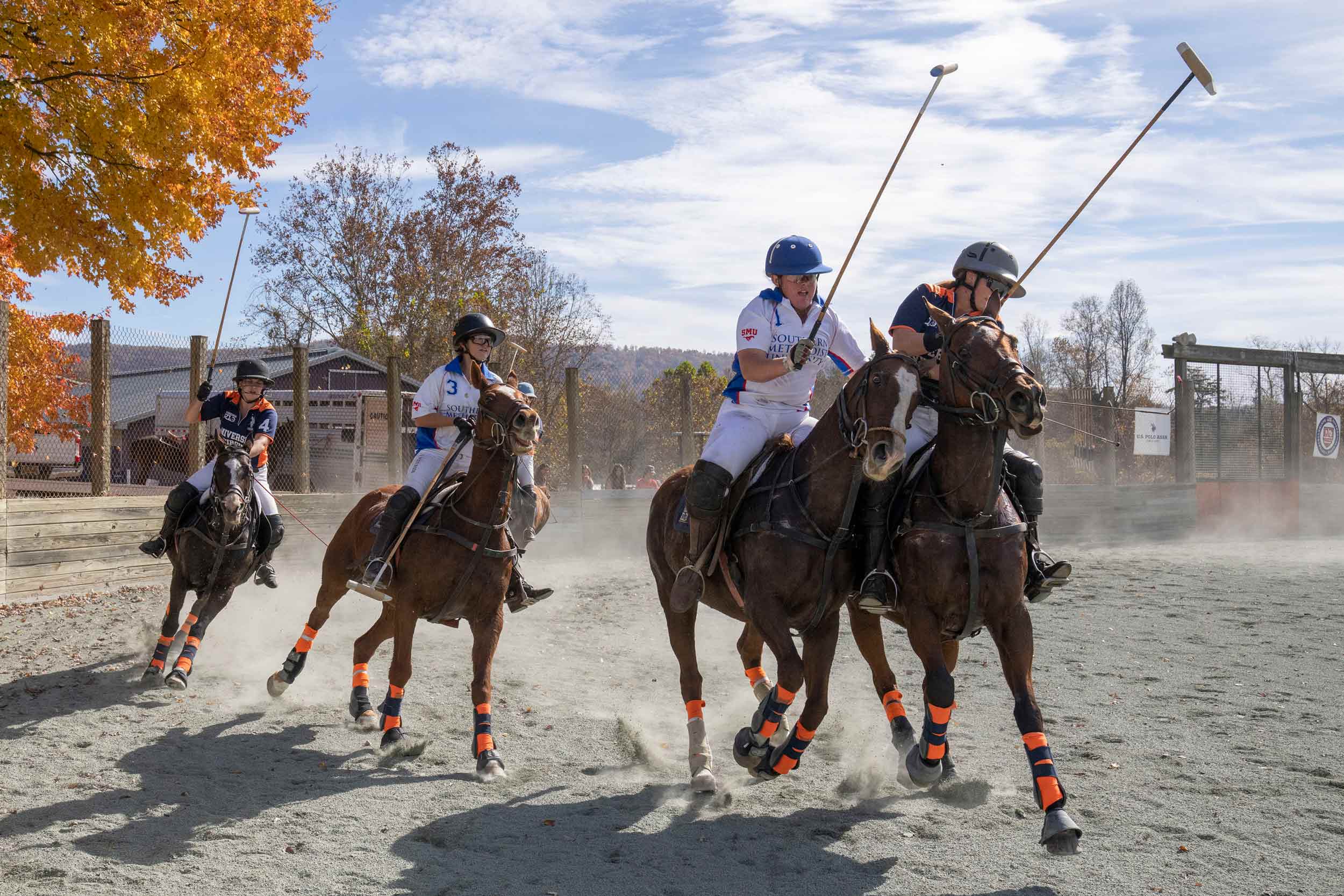 UVA polo players on horses going after ball against opponents