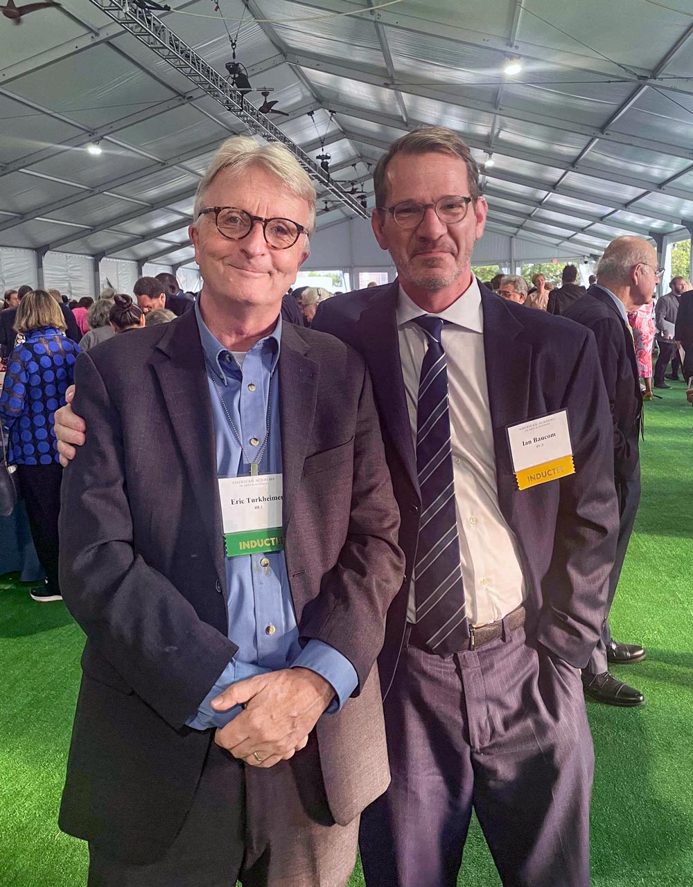 Eric Turkheimer and Ian Baucom pose for a photo at an event under a tent