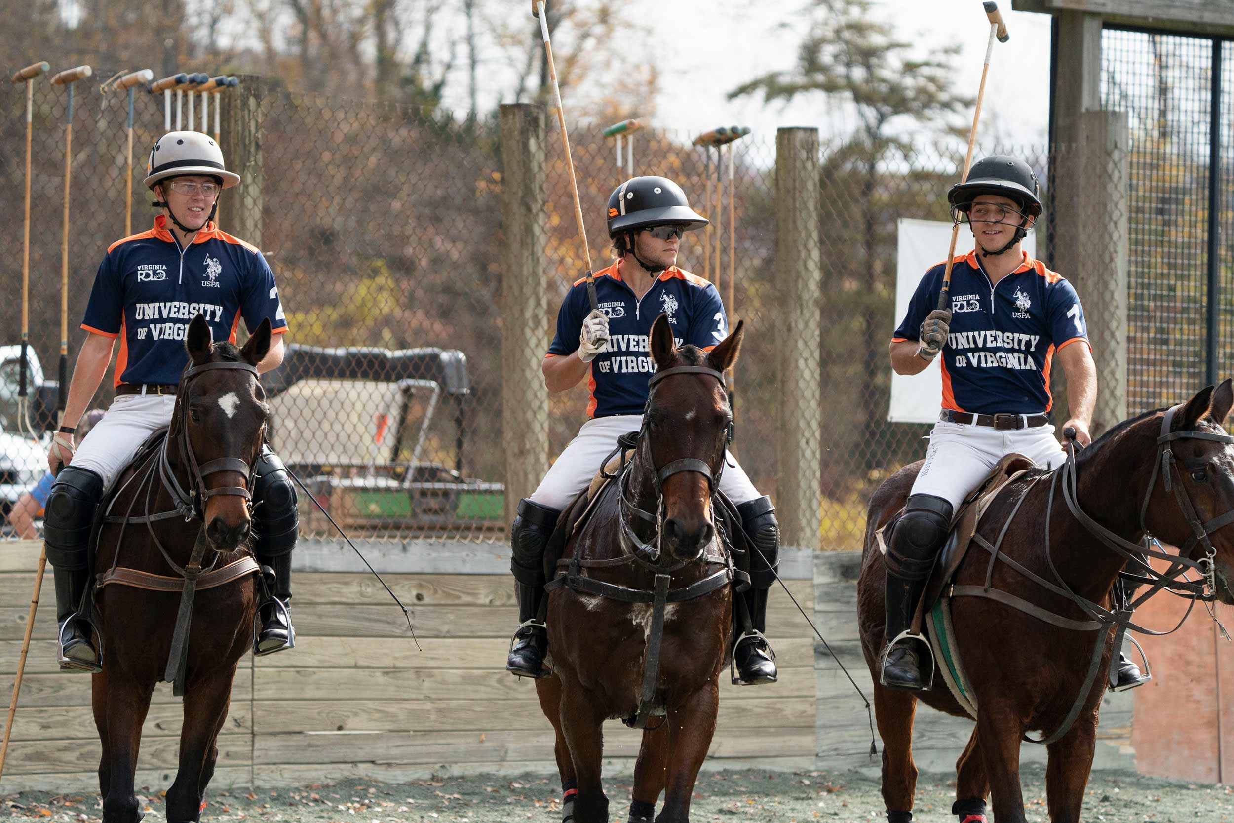 UVA polo players talking while sitting on horses