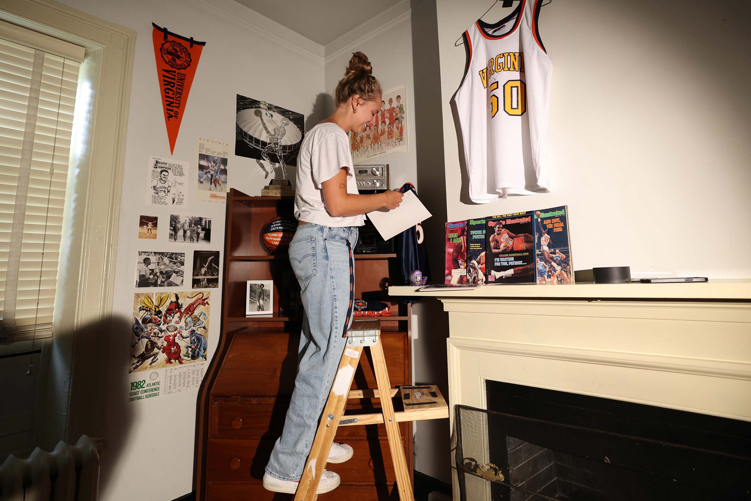 Emily Faith on a ladder documenting borrowed decor