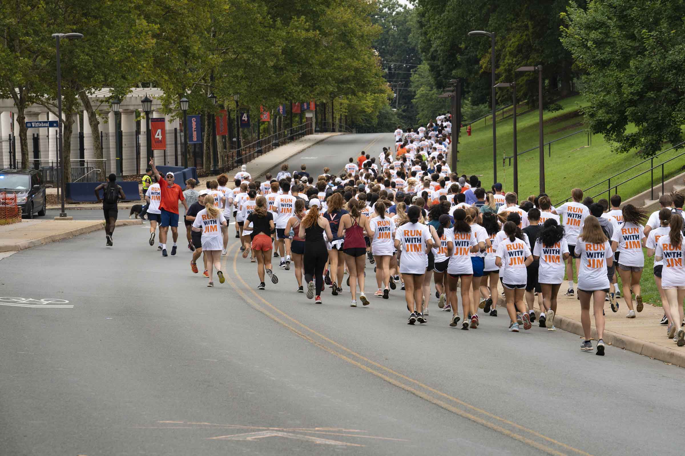 Hundreds of students in Run with Jim tee-shirts run down Alderman Road.