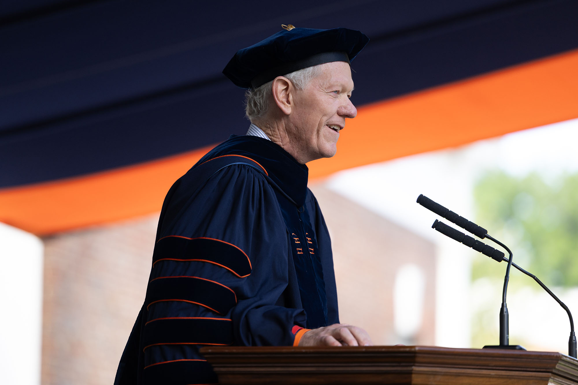 Scott Beardsley standing at the podium in his regalia addressing the audience.