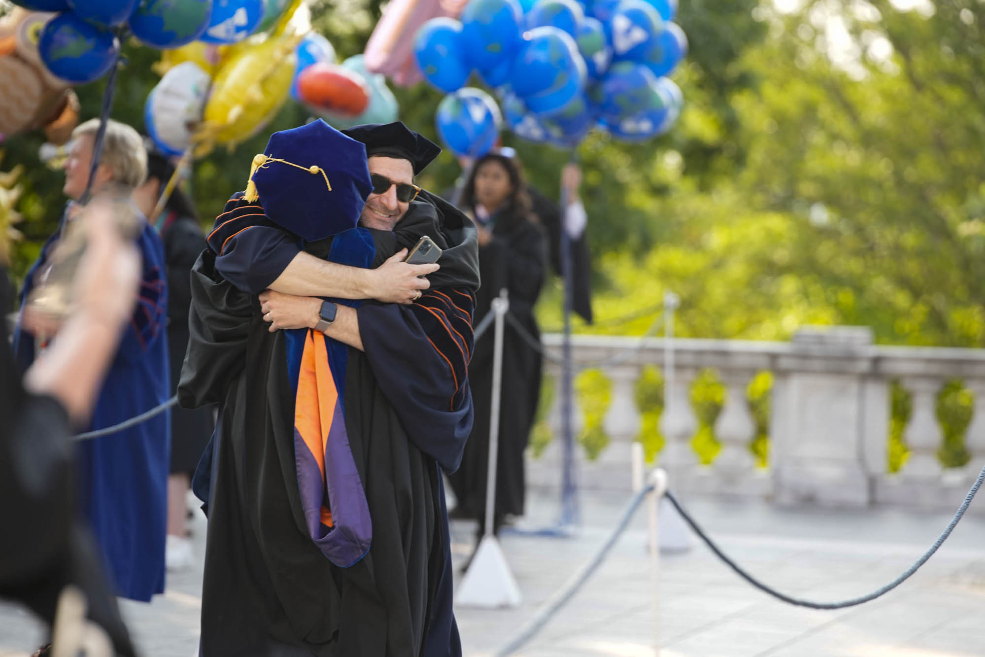 Two graduates celebrating with a hug