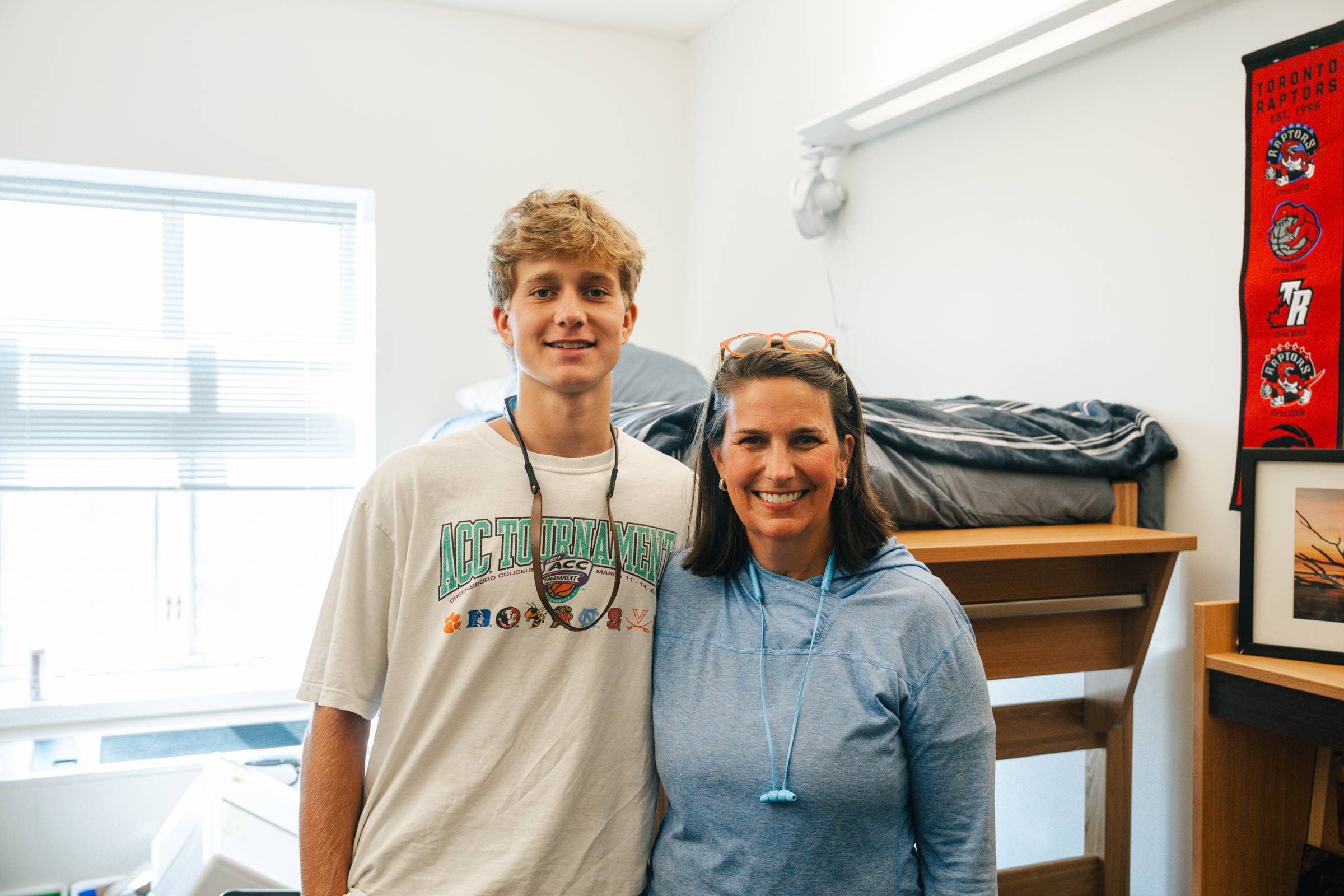 A student and parent pose for a photo in the student's new dorm room