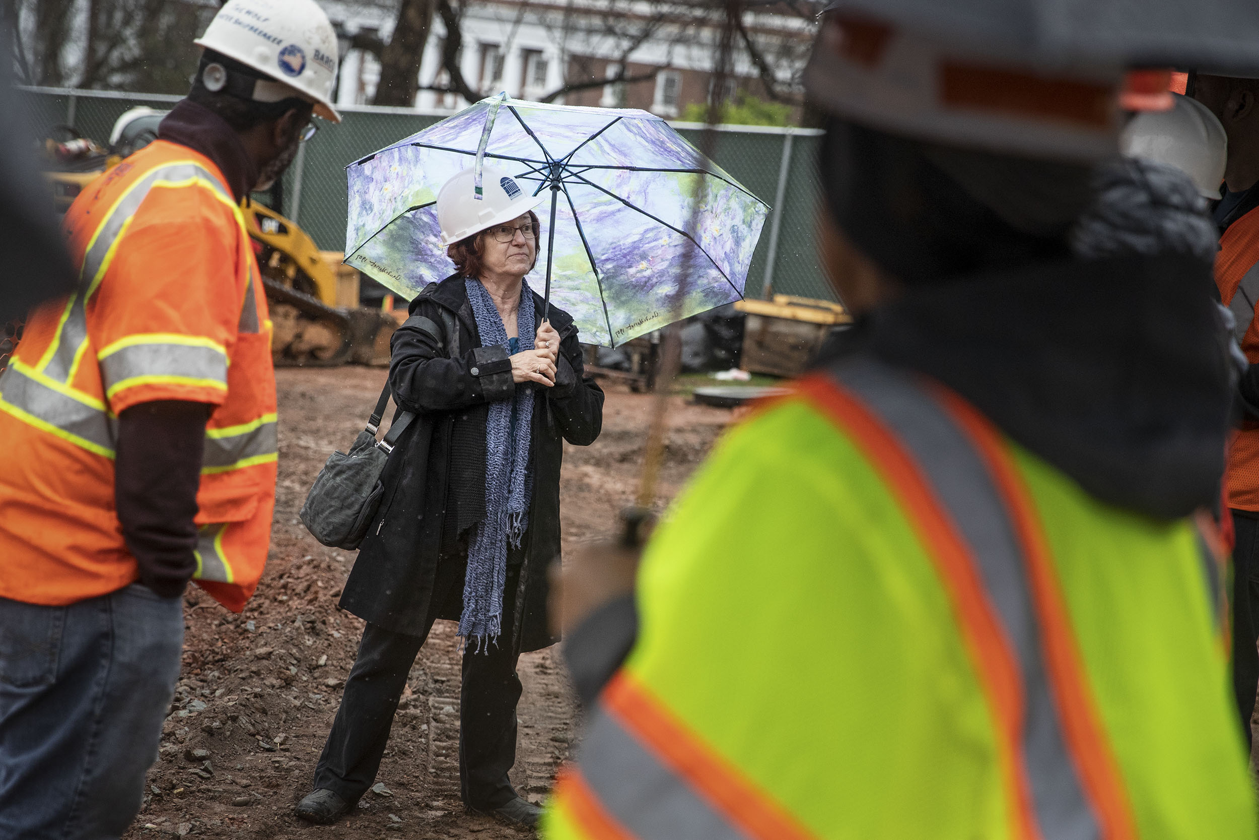 Mary Hughes surveying construction project while construction workers work
