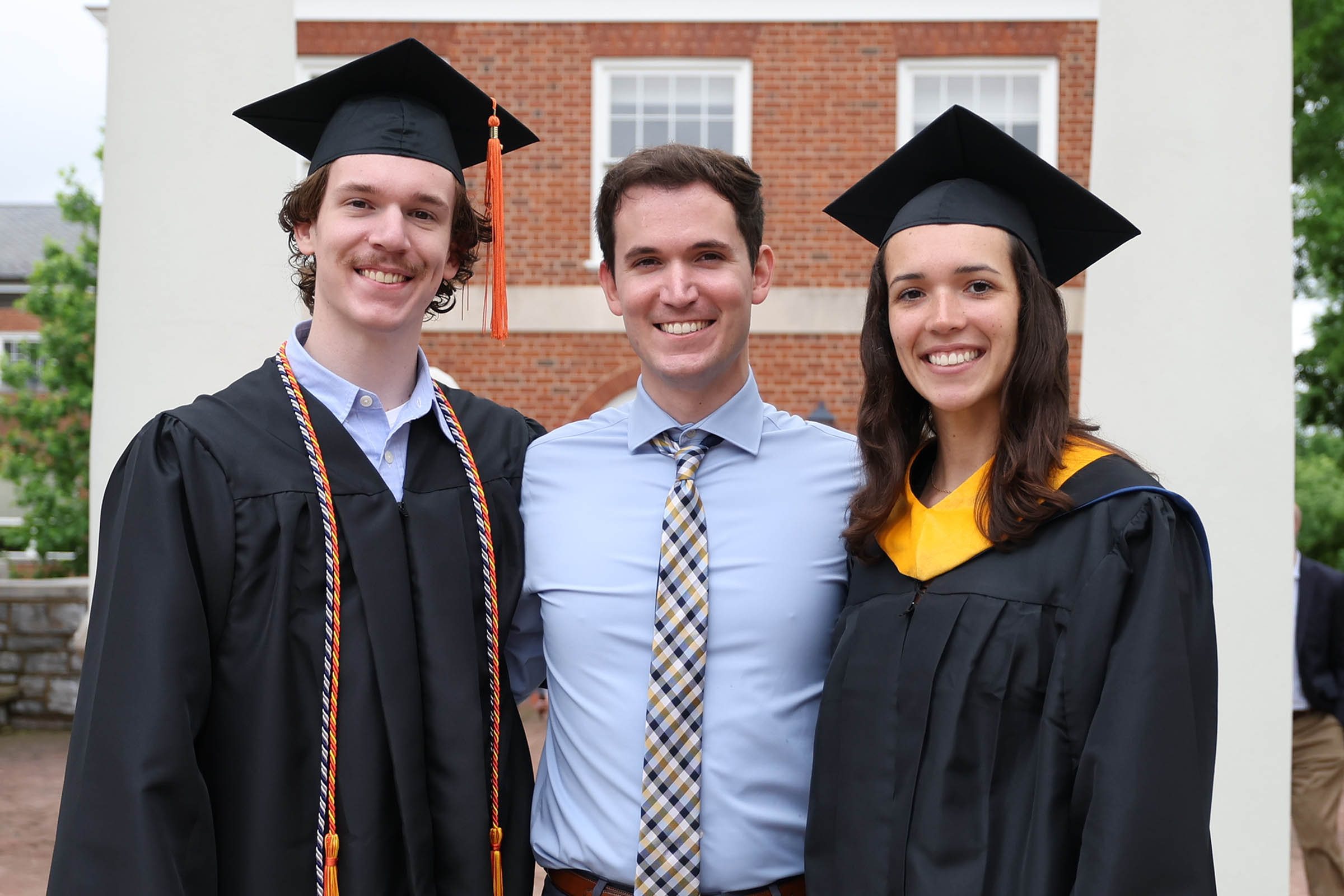 2018 alumnus J.C. Panagides, center, returned to Grounds to attend the graduations of his siblings, Anthony, left, a computer science major; and Reanna, right, who received a master’s degree in data science.