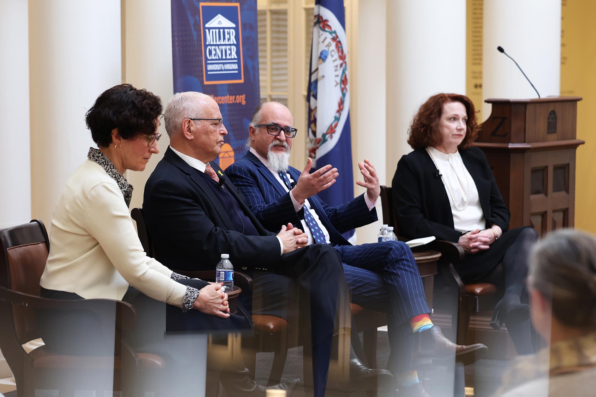 Panel members speak seated on stage