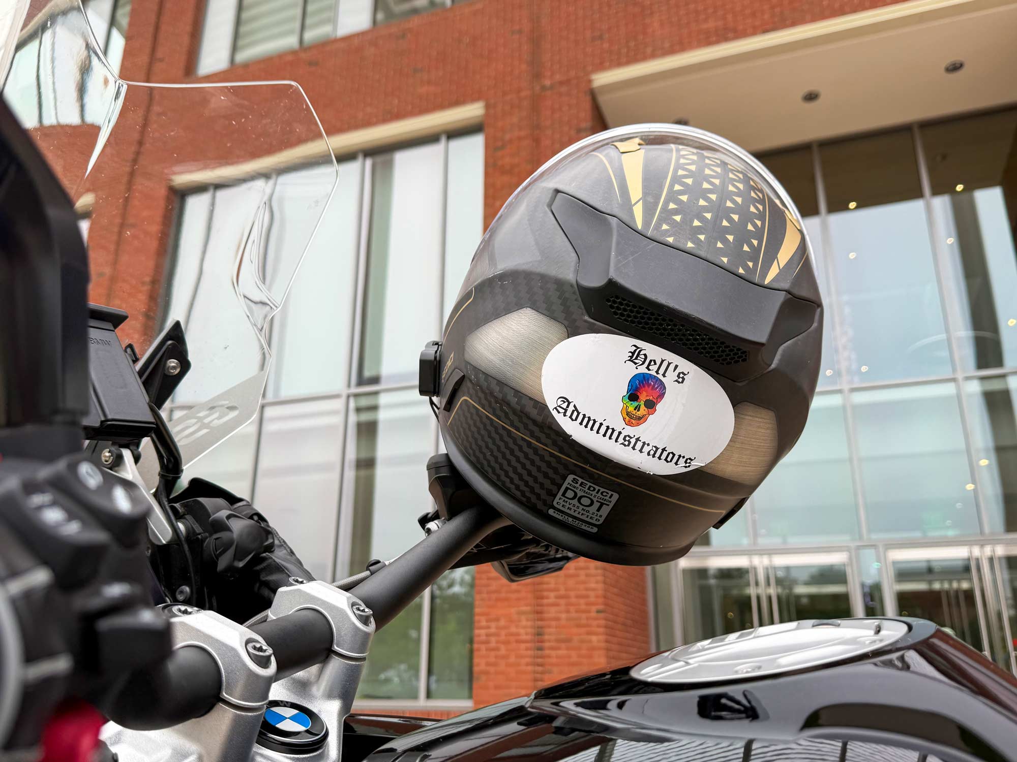 close up on a motorcycle helmet with a sticker that reads “Hell’s Administrators”