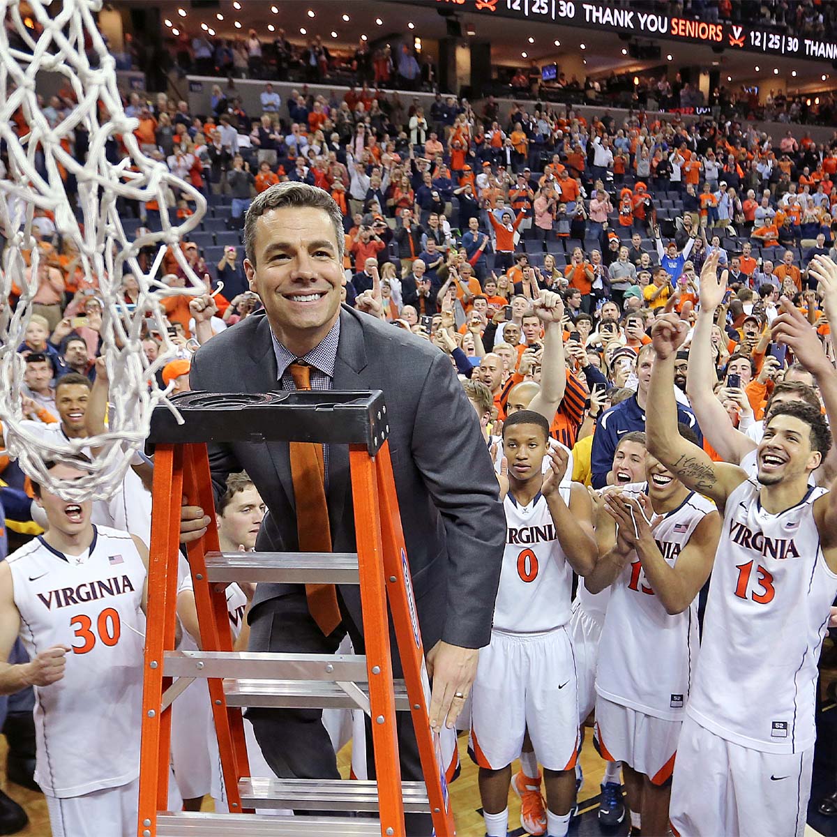 Tony Bennett climbing up a ladder to cut off the game winning net after his first ACC Championship win with UVA.