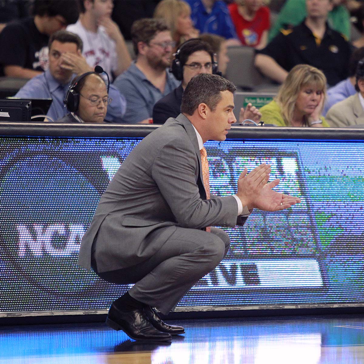 Tony Bennett squating court side watching the game play closely during the 2012 NCAA tournament.