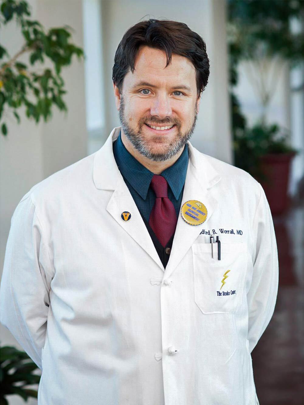 Worrall, in a white coat, smiles at the camera