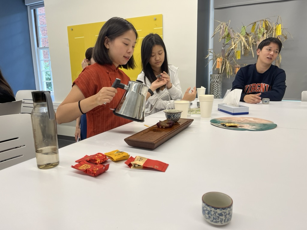 A woman pouring water from a kettle to make tea in a UVA classroom