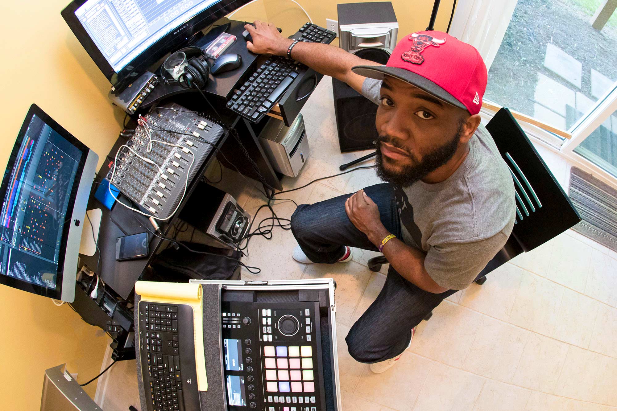 Carson looks up at the camera while sitting at his computer making music