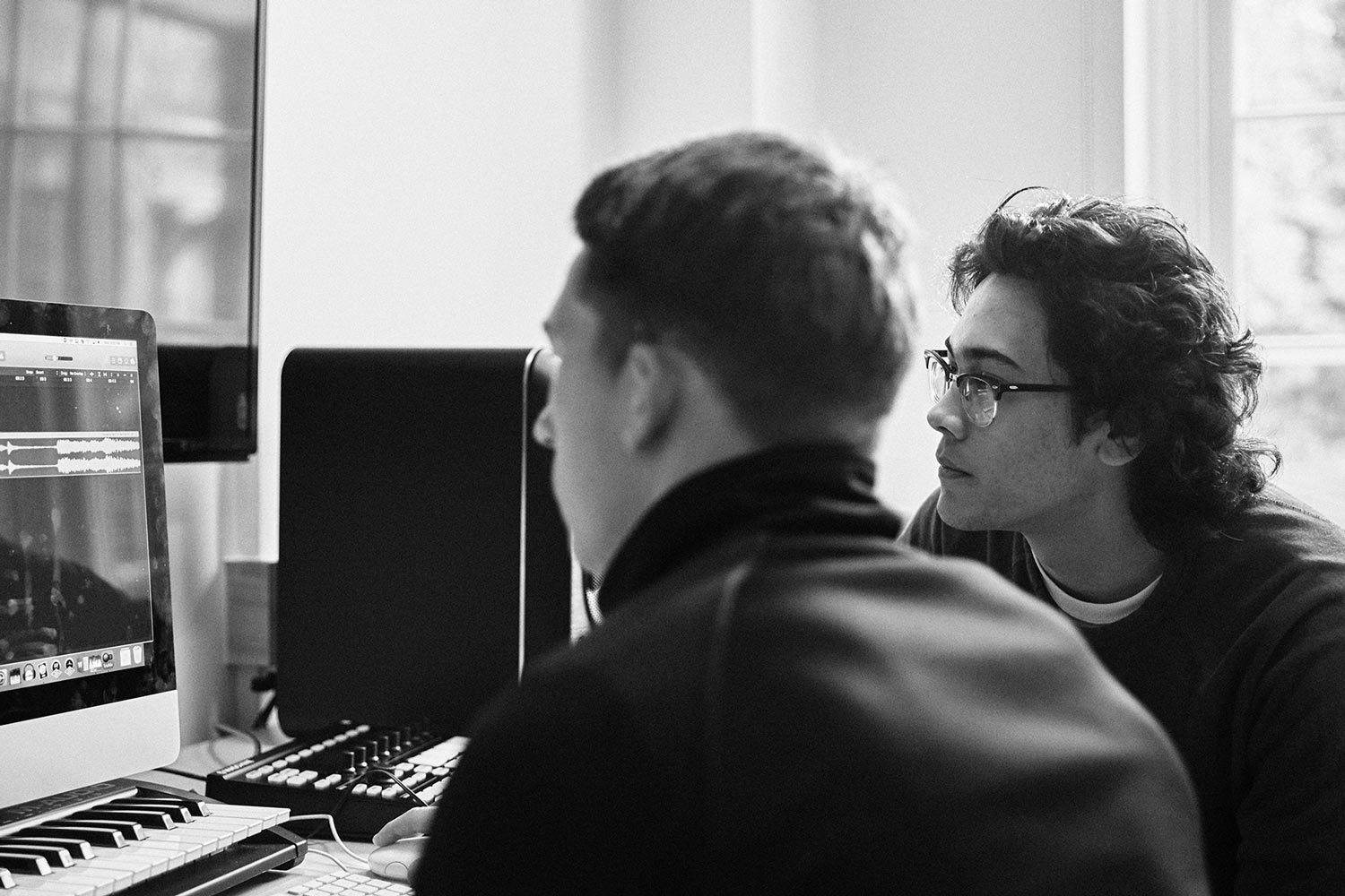 Two students working on a computer together, black and white image