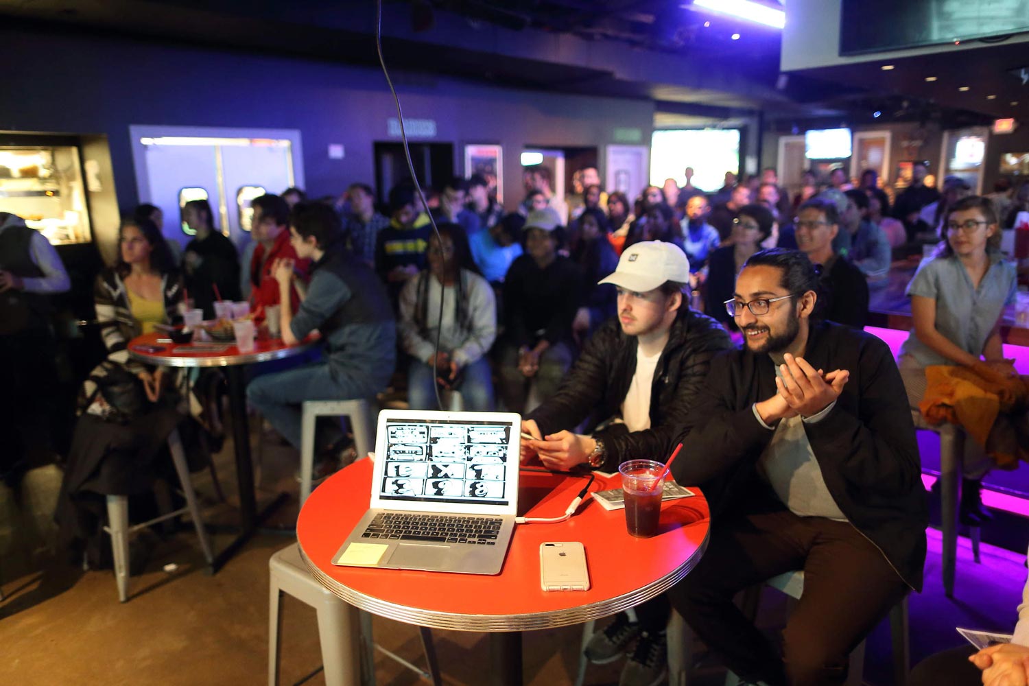 Students in a bar listening to performers on stage