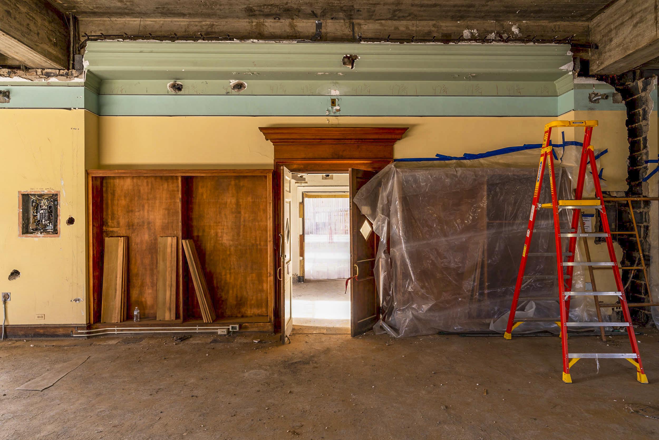 gutted ceiling and ladders in a room that has been completely gutted in the Alderman Library Renovation project