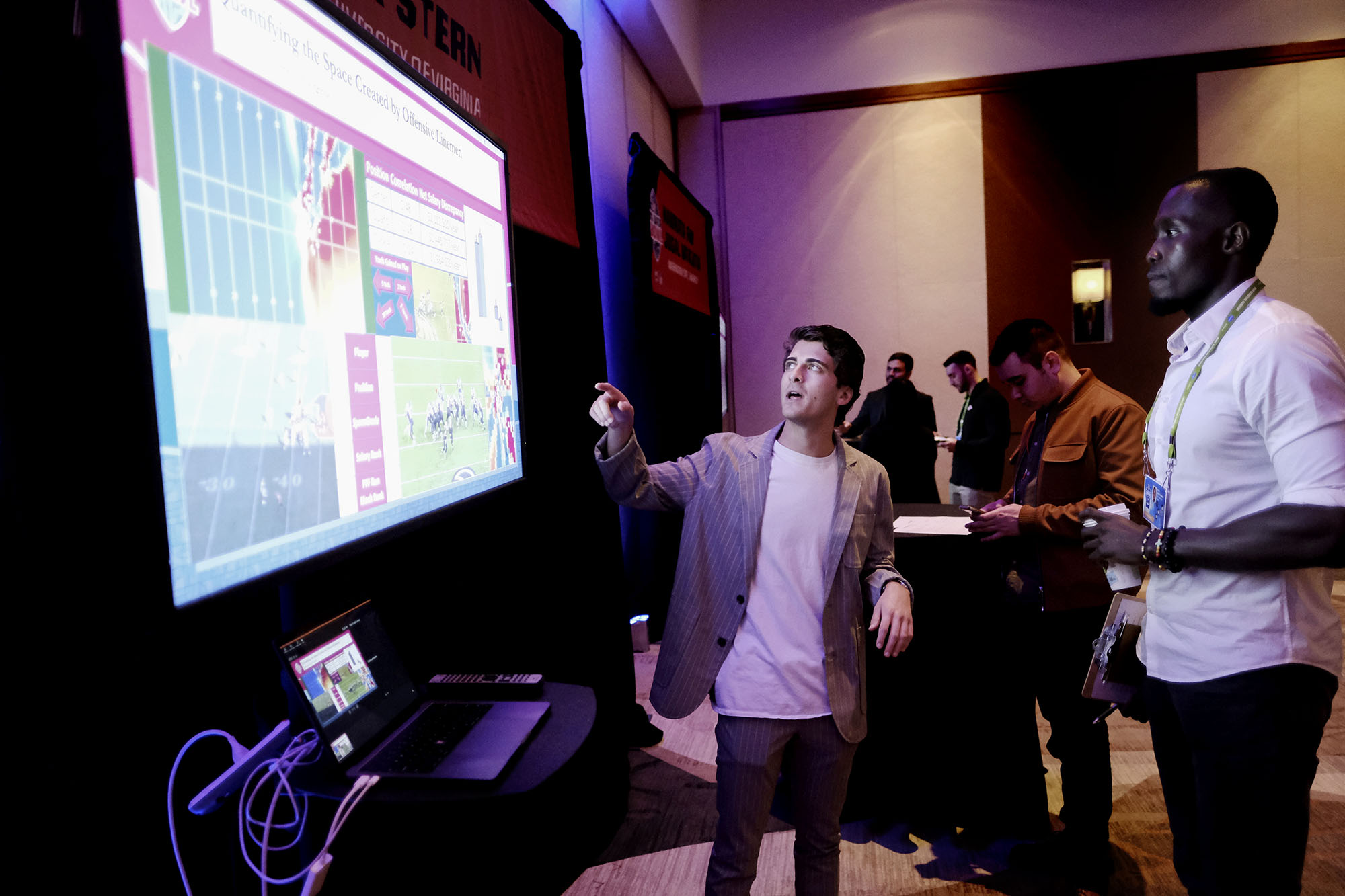 Alex Stern pointing to a screen while talking to another person