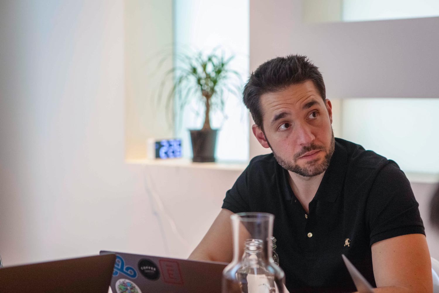 Alexis Ohanian sitting at a table working on a laptop
