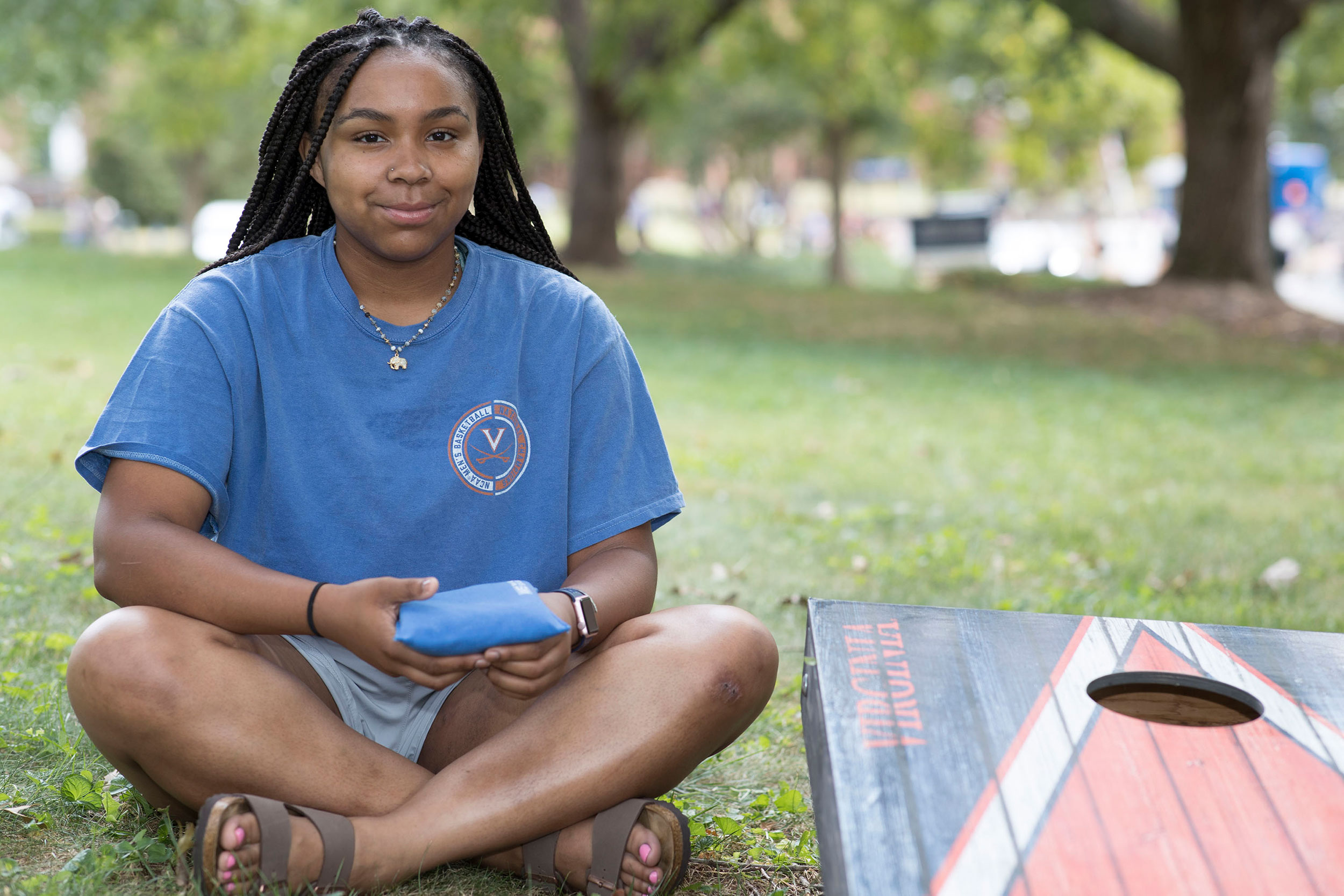 Alita Robinson sits holding a corn hole bag