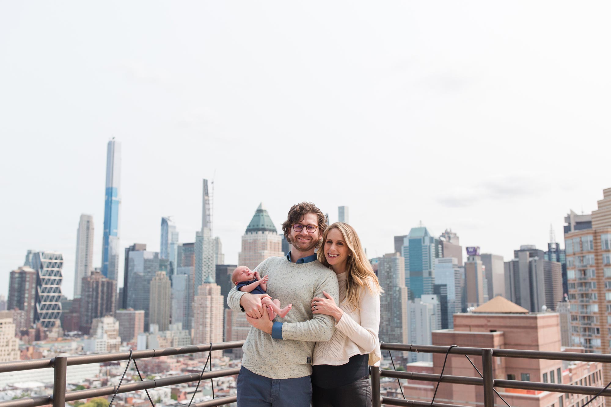 Allie Egan and her husband, Jim, and son Cooper, pose for photo with city skyline behind them