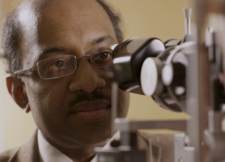 Dr. Jayakrishna Ambati looking into a ophthalmoscope