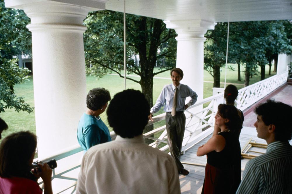 Group standing on a second floor Lawn balcony talking
