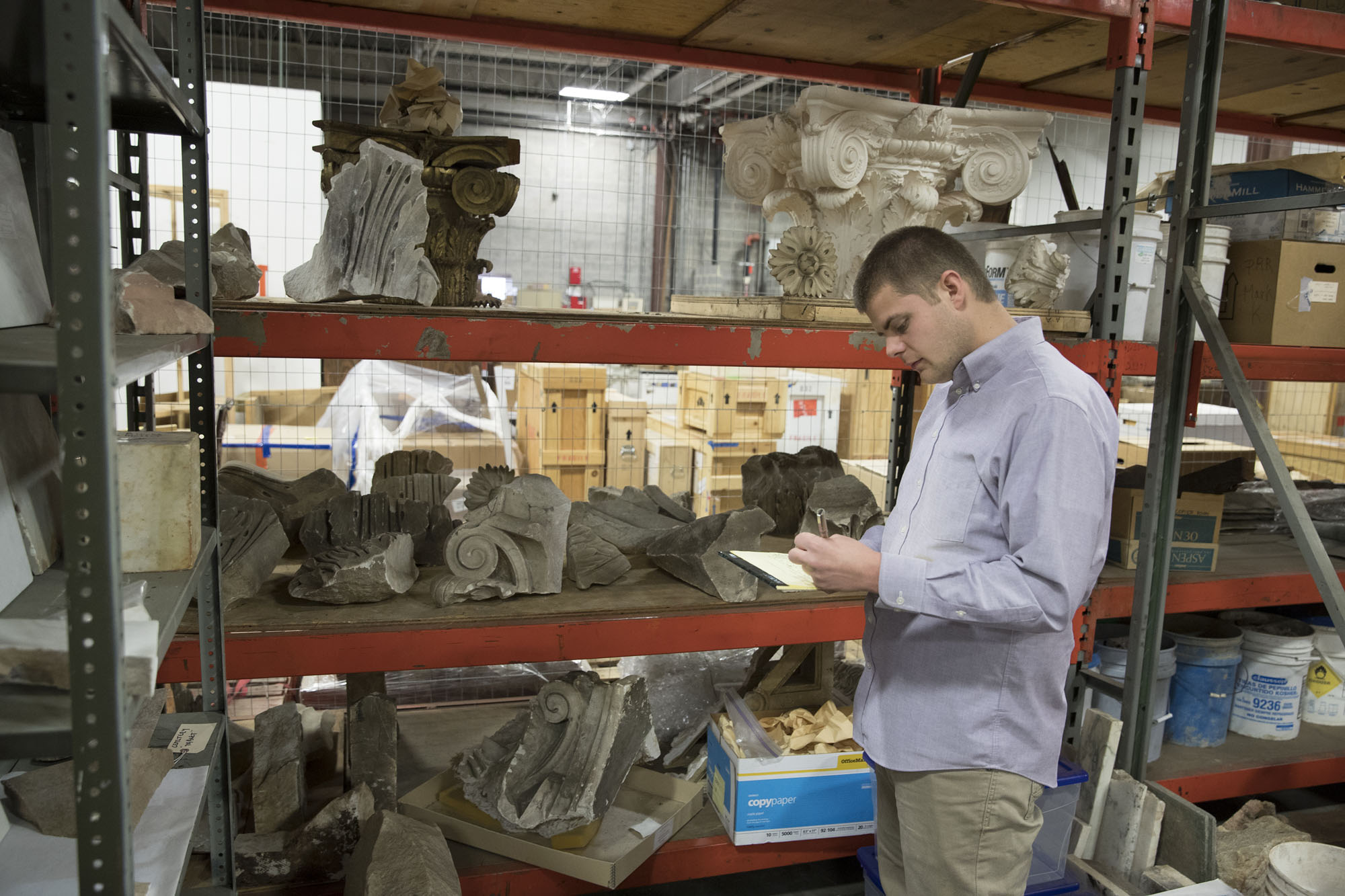 Andrew Ashcraft looking at artifacts from a shelf