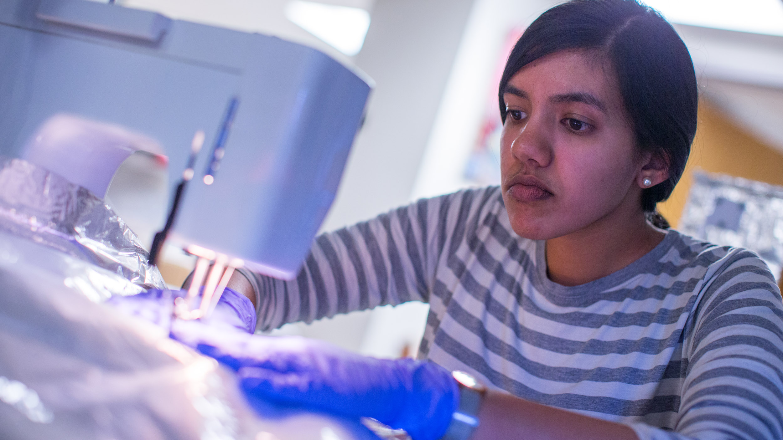 Recent UVA graduate and now lab technician Mita Tembe assembles specialized mylar thermal radiation blankets needed to keep the APOGEE instrument at its operating temperature of -300 degrees Fahrenheit.