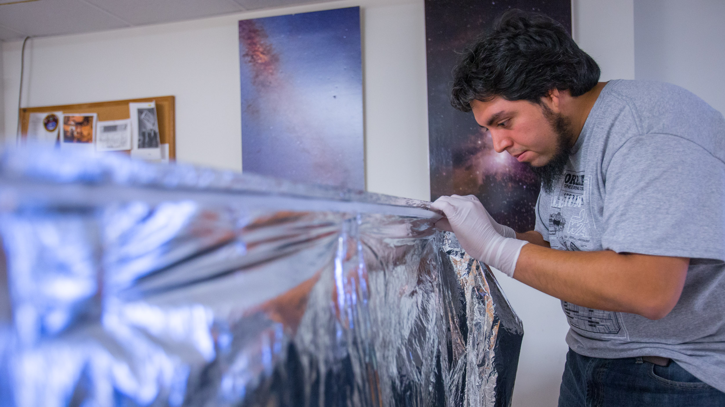 Visiting Chilean graduate student Juan Pablo Colque Saavedra of the University of Antofagasta test-fits special thermal radiation blankets to a mock-up of the APOGEE instrument radiation shield.