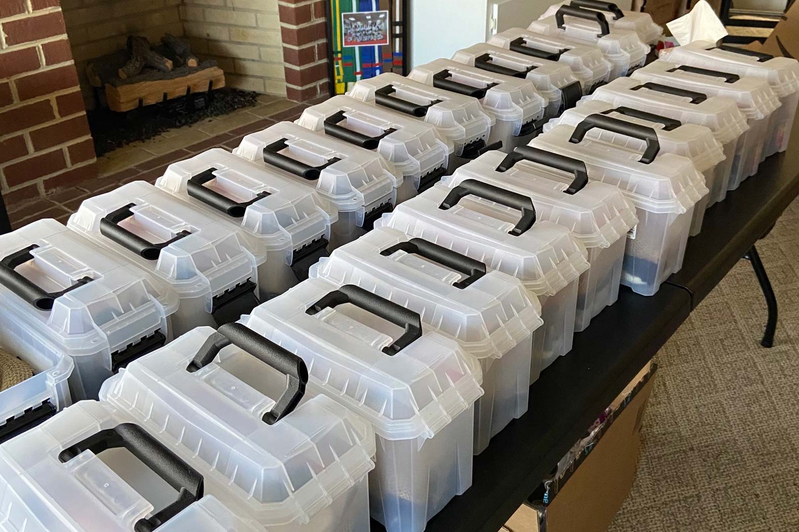 Clear plastic bins with black handles on tables