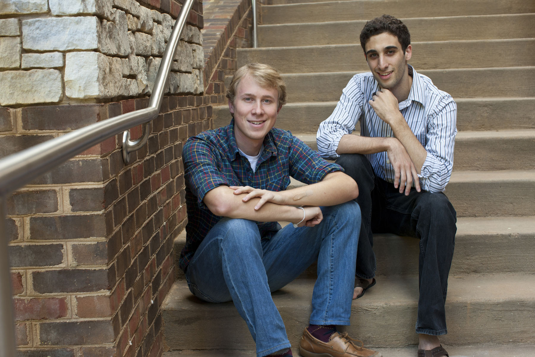 Matt Savarese and Jeffery Luppino-Esposito sitting on steps smiling at the camera