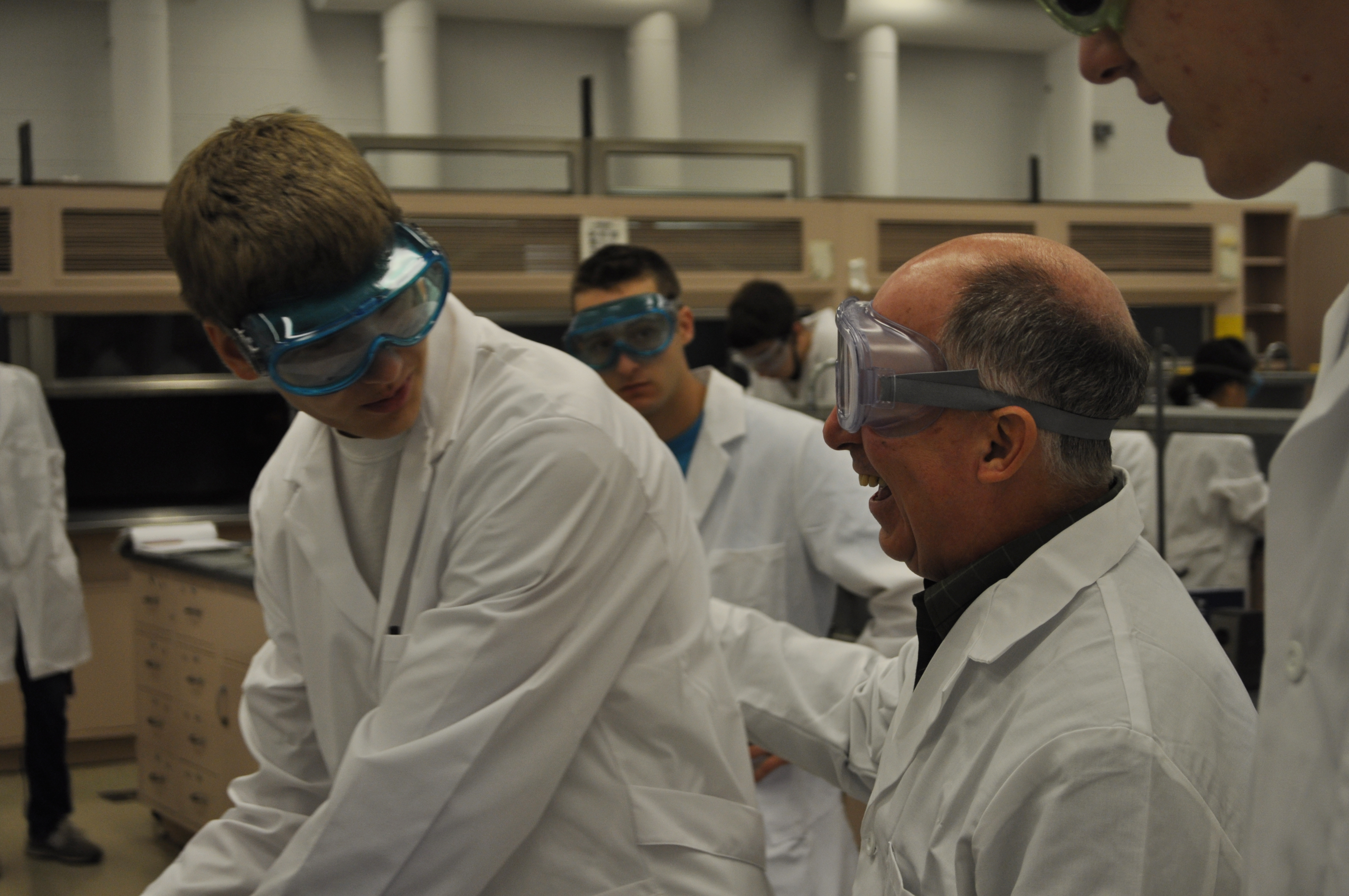 Robert Burnett pats a student on the back during a lab