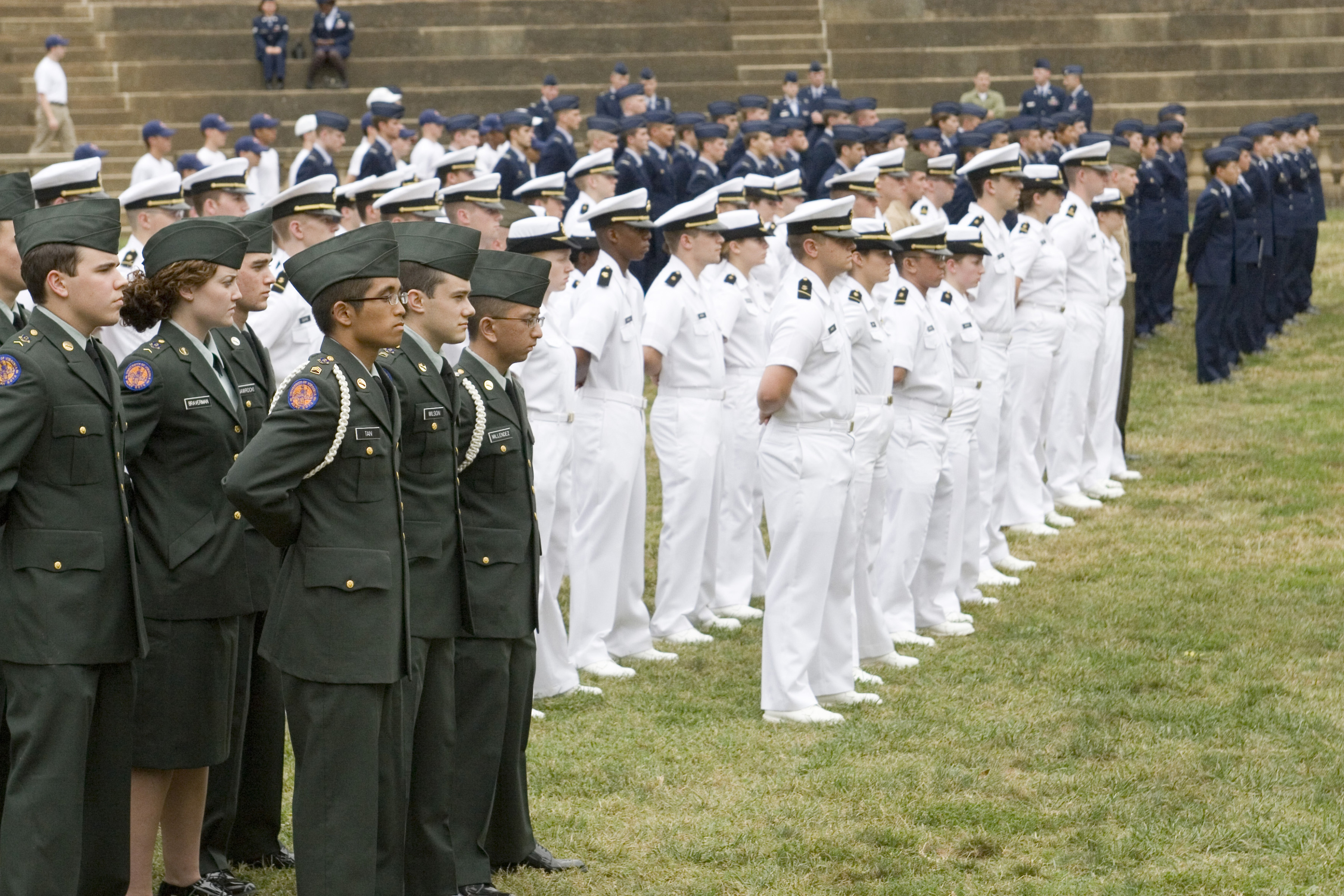 ROTC cadets in military dress uniforms from various branches stand during a ceremony to honor POWs, MIAs, and Veterans
