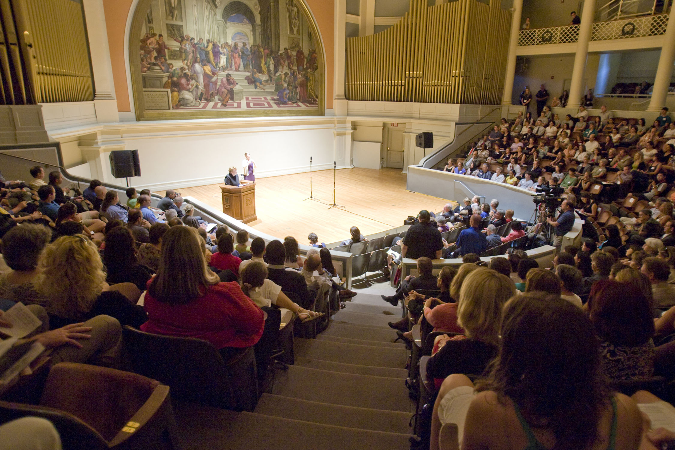 President Sullivan stands at a podium giving a speech to an auditorium full of people