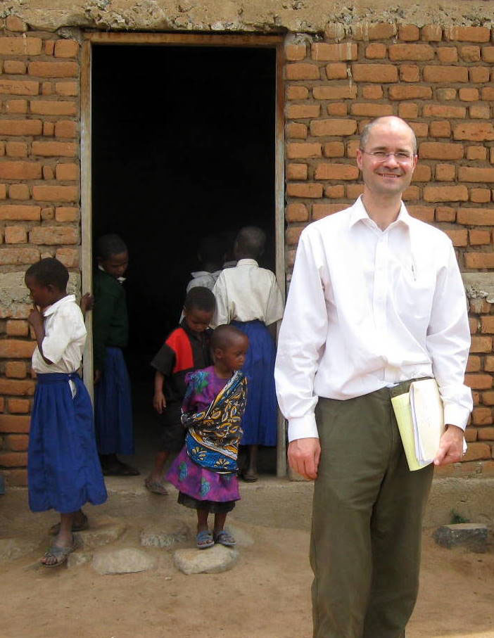 Dr. Eric Houpt stands smiling outside of a medical clinic in Africa