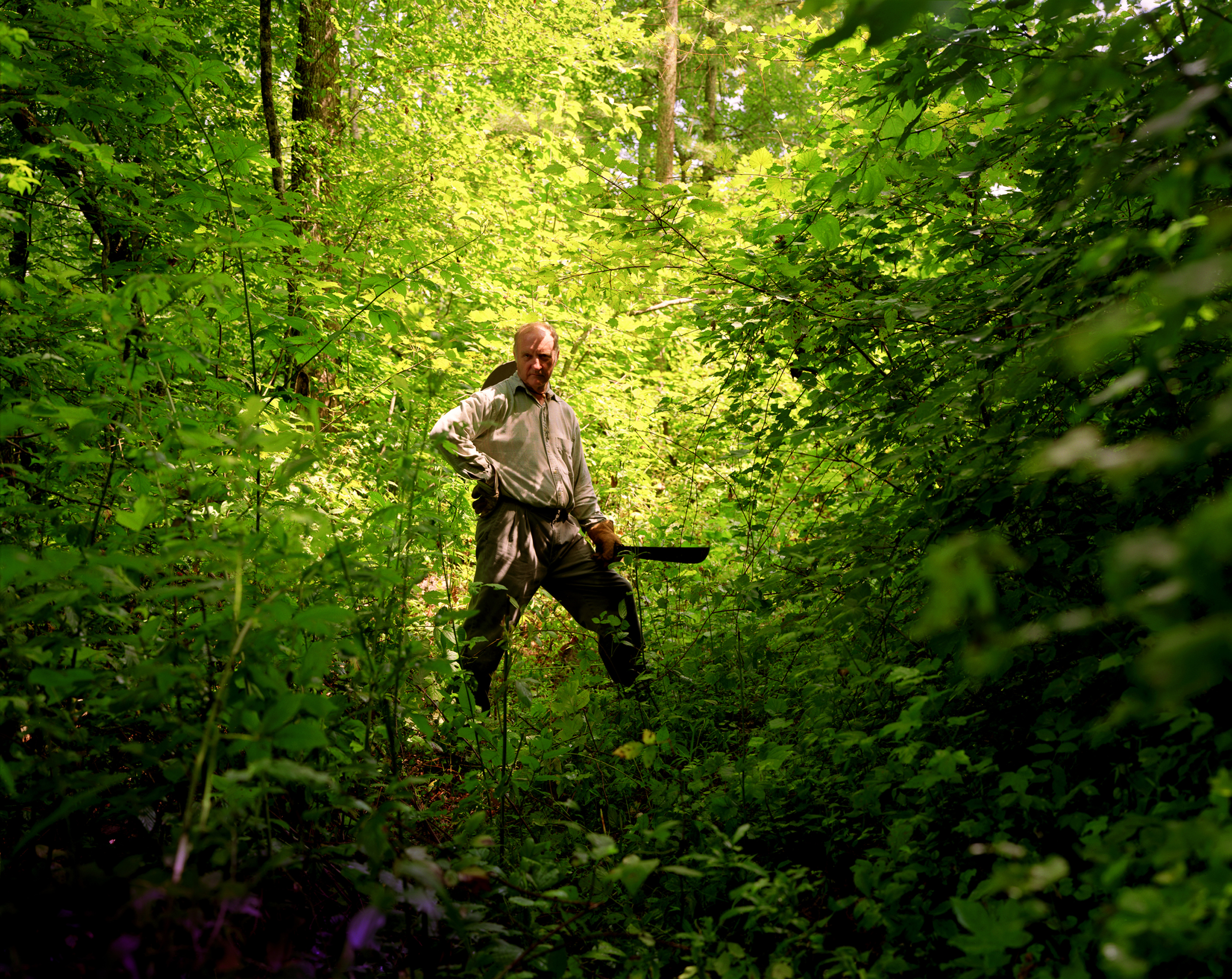 Man standing in the woods with a Machete