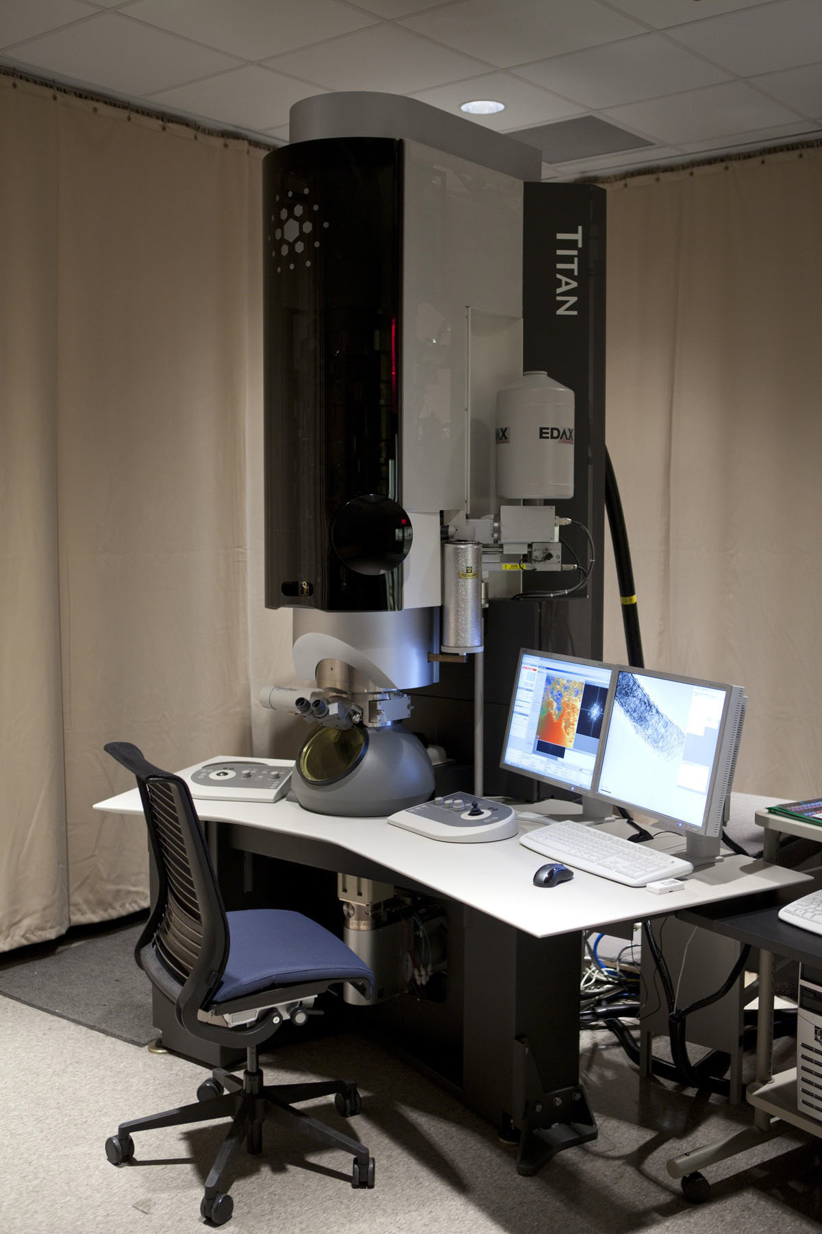 Scanning-transmission electron microscope on a desk next to a computer