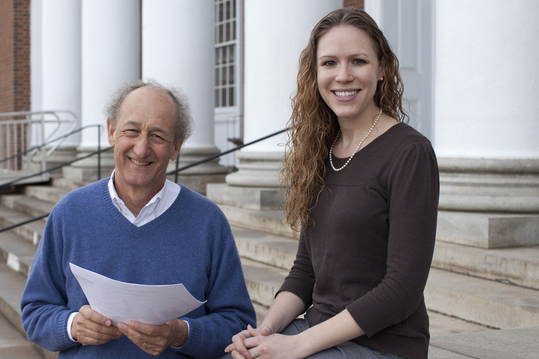 James Galloway and Allison Leach sitting on a buildings steps smiling at the camera