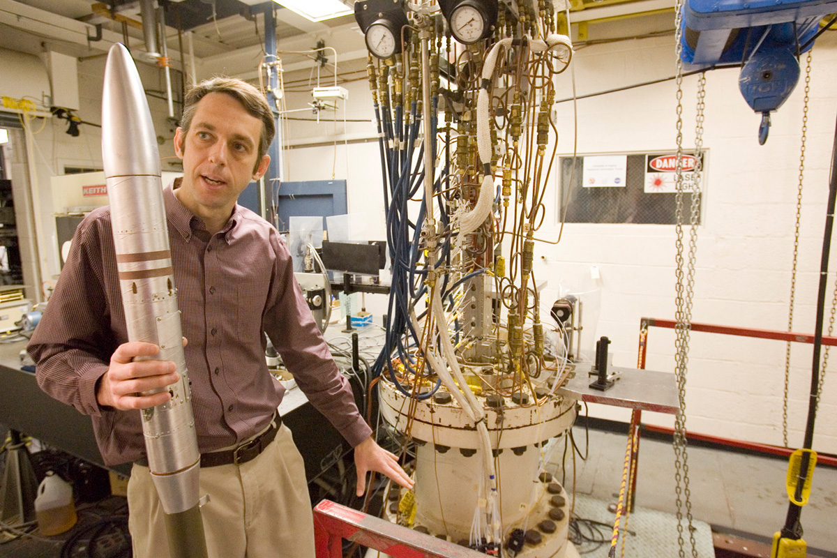 Christopher Goyne holds a rocket while talking