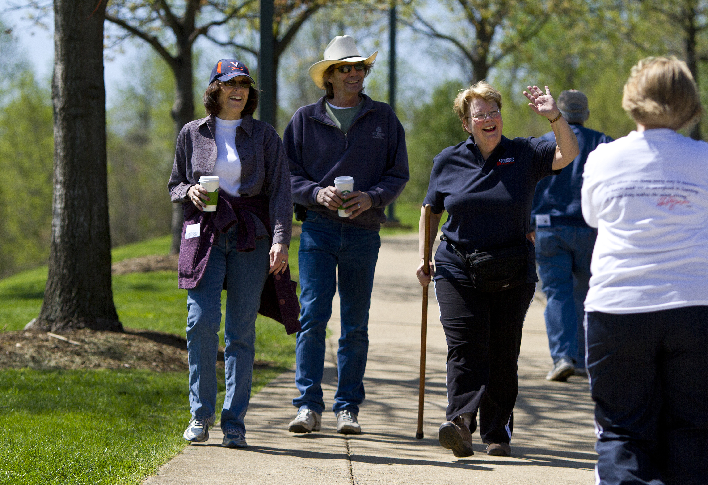 People walking on a sidewalk left to right: Susan Carkeek, her husband, Kelly, and President Sullivan 
